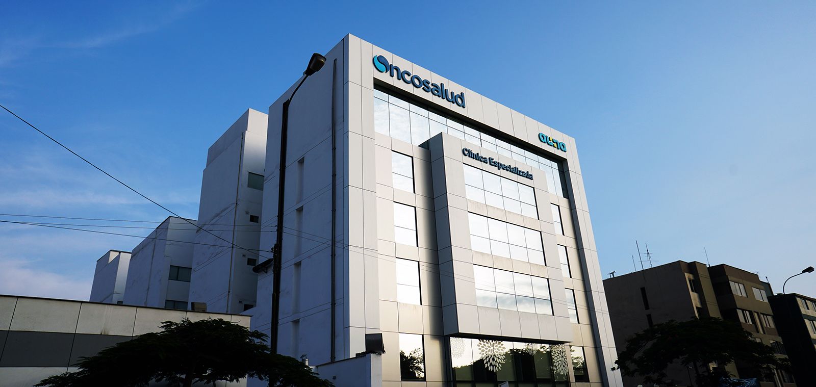 Médico oncólogo revisando resultados de exámenes con un paciente en consulta especializada de Clínica Oncosalud en San Borja, Lima