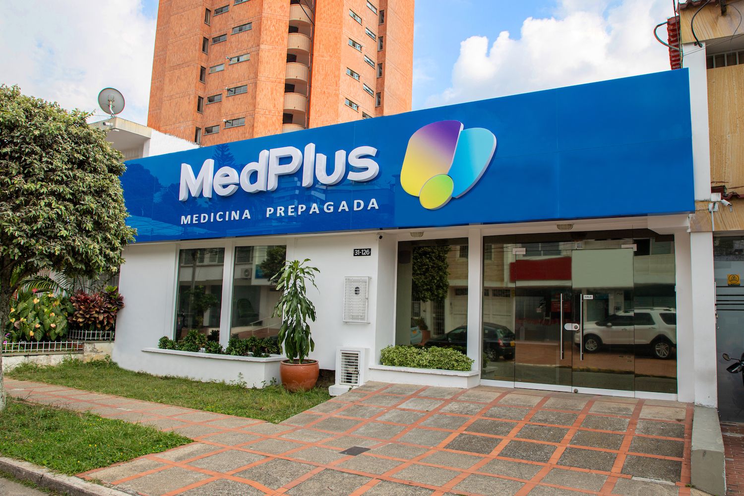 Fachada de un centro médico de MedPlus Medicina Prepagada en Colombia con pacientes ingresando a consulta