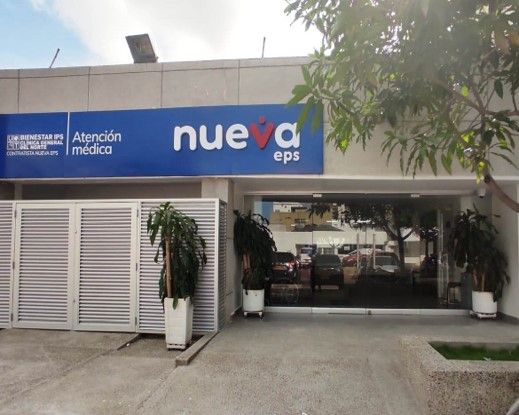 Fachada de sede de Nueva EPS en Colombia con acceso a ventanillas de atención al afiliado y señalización institucional visible